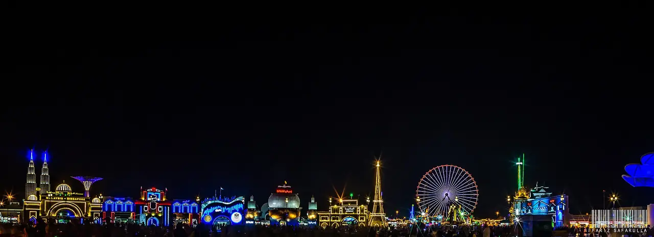 เส้นขอบฟ้าของ Global Village ยามค่ำเห็นชิงช้าสวรรค์และอาคารบูธ ภาพจาก Wikimedia Commons ผู้ถ่าย Fariz Safarulla สัญญา CC BY-SA 2.0