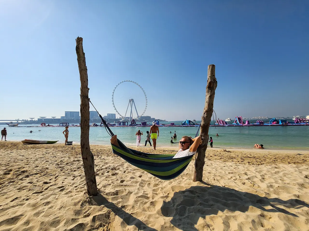 ชายหาด JBR ในวันแดดจัด เห็นล้อ Ain Dubai และสวนน้ำพองลมนอกชายฝั่งอยู่ไกล ๆ ภาพจาก Wikimedia Commons ผู้ถ่าย Saaremees สัญญา CC BY-SA 4.0