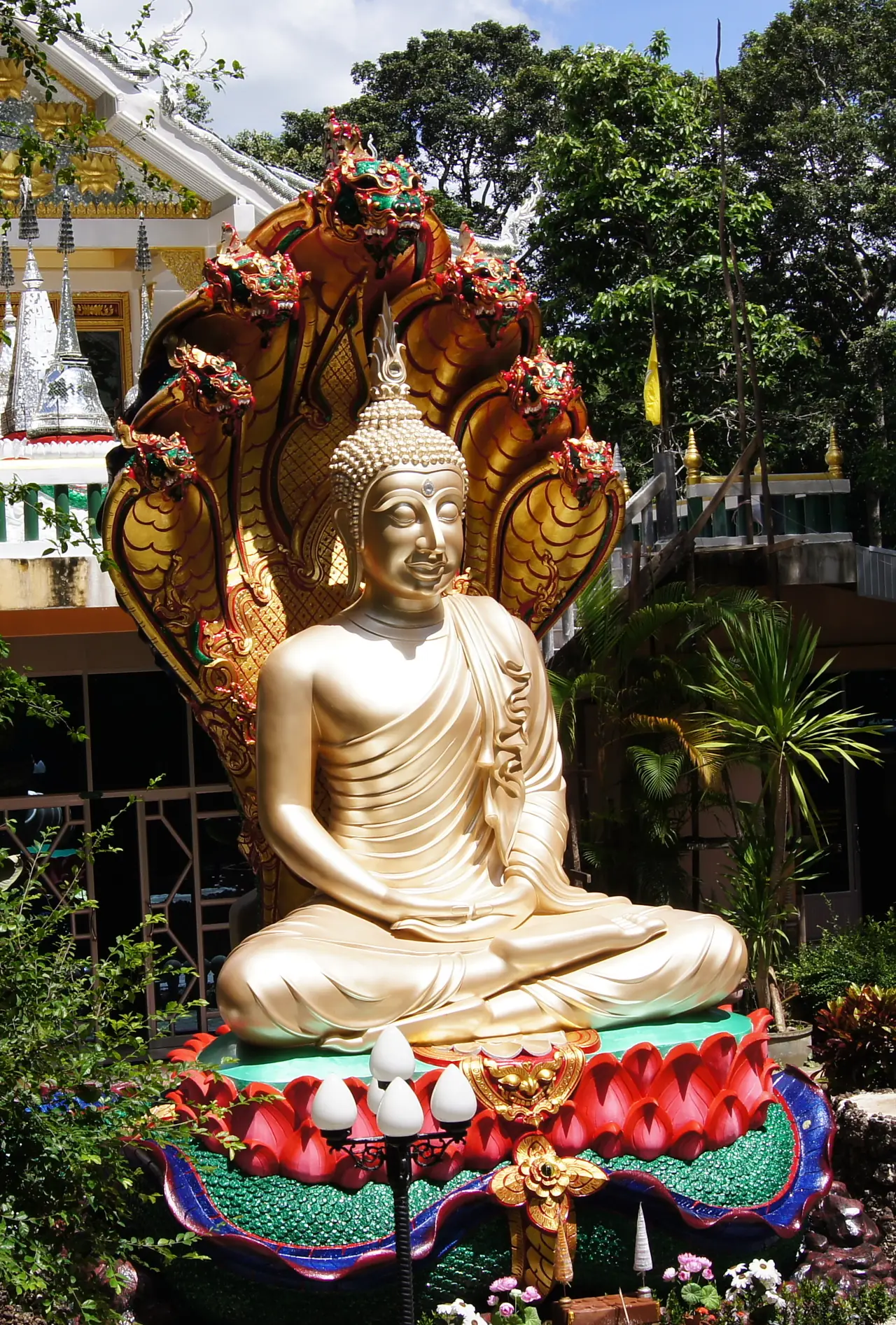 A golden naga-sheltered Buddha in Amnat Charoen, from the Luang Pho Nakha Ong Saen category on Wikimedia Commons