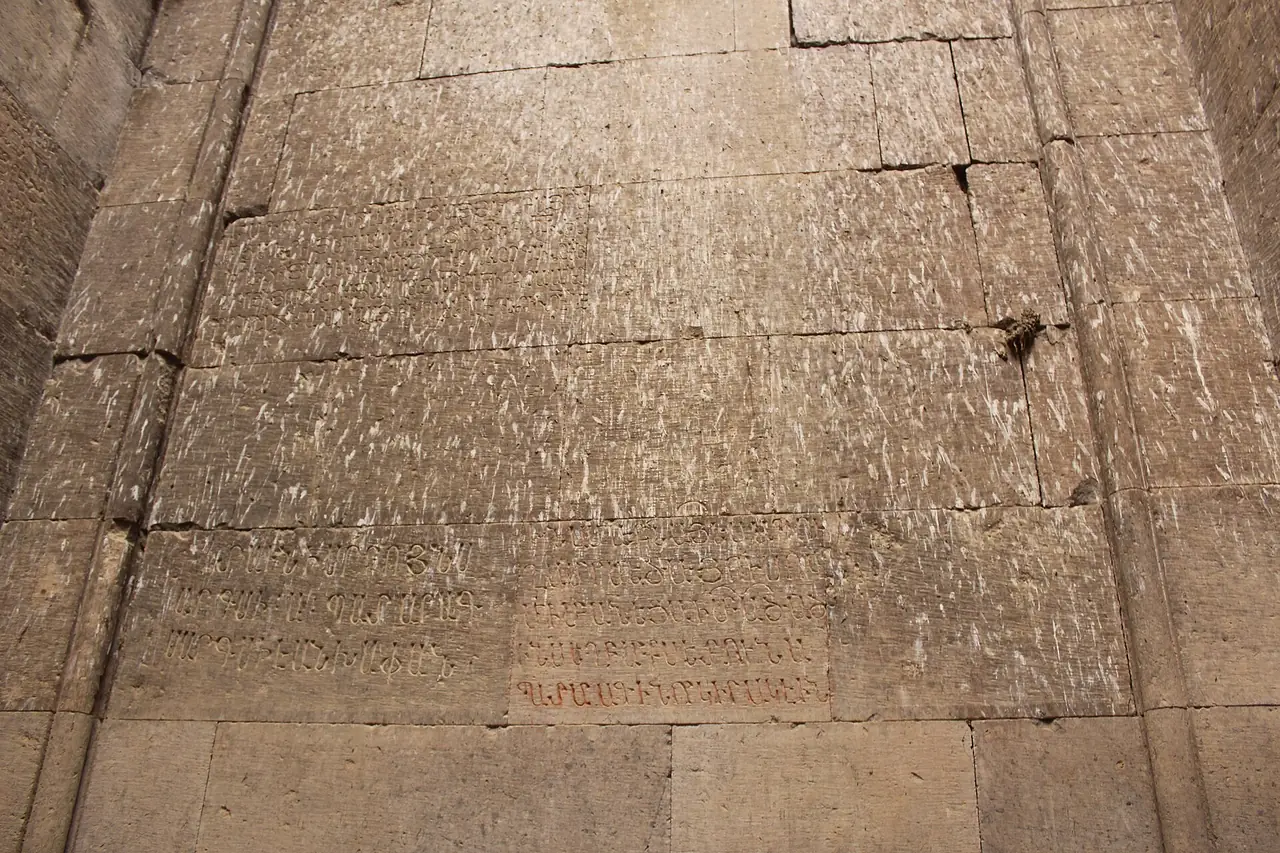 ผนังหินแกะสลักและร่องรอยจารึกที่โกชาวังก์ ภาพจาก Wikimedia Commons ผู้ถ่าย Soghomon Matevosyan สัญญา CC BY-SA 4.0 เป็นภาพรายละเอียดผนังไม่ใช่ภาพรวมของอาราม