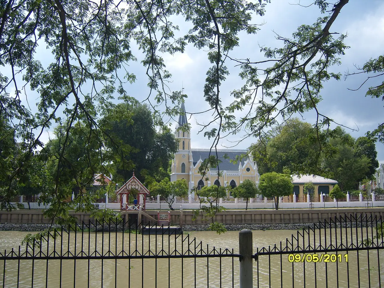 พระอุโบสถทรงกอทิกของวัดนิเวศธรรมประวัติ มองผ่านรั้ว ภาพถ่ายจาก Wikimedia Commons (Phong Phat G, CC BY-SA 3.0)