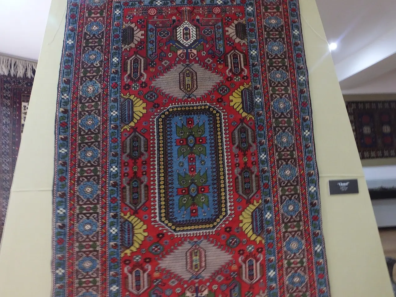 พรมกูบาลายเหรียญสีแดงน้ำเงินที่แสดงในพิพิธภัณฑ์ ภาพจาก Wikimedia Commons ผู้ถ่าย Aykhan Zayedzadeh สัญญา CC BY-SA 4.0