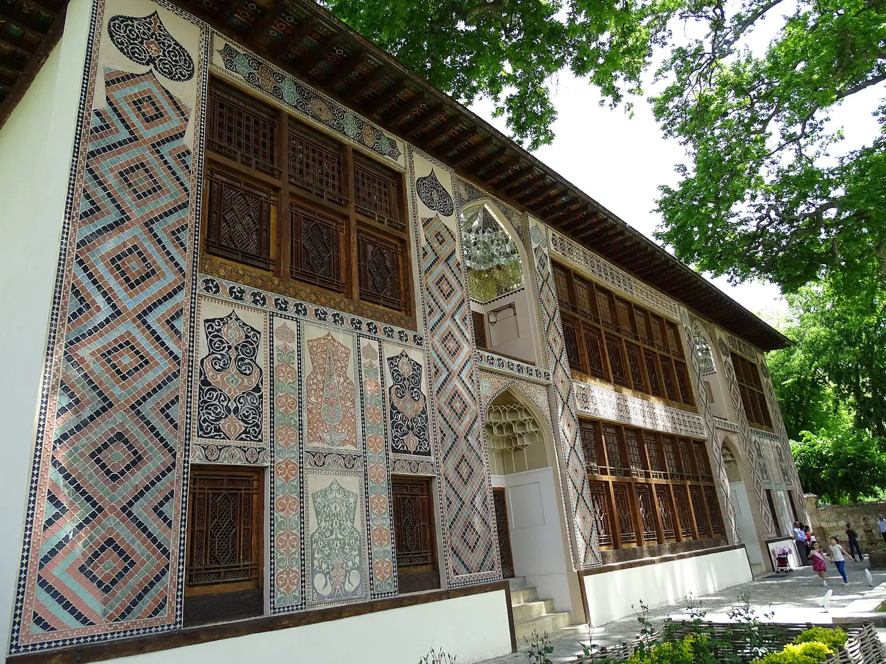 ลายกระเบื้องและหน้าต่างไม้ฉลุที่ด้านหน้าวังข่านแห่งเชกี ภาพจาก Wikimedia Commons ผู้ถ่าย Adam Jones สัญญา CC BY-SA 2.0