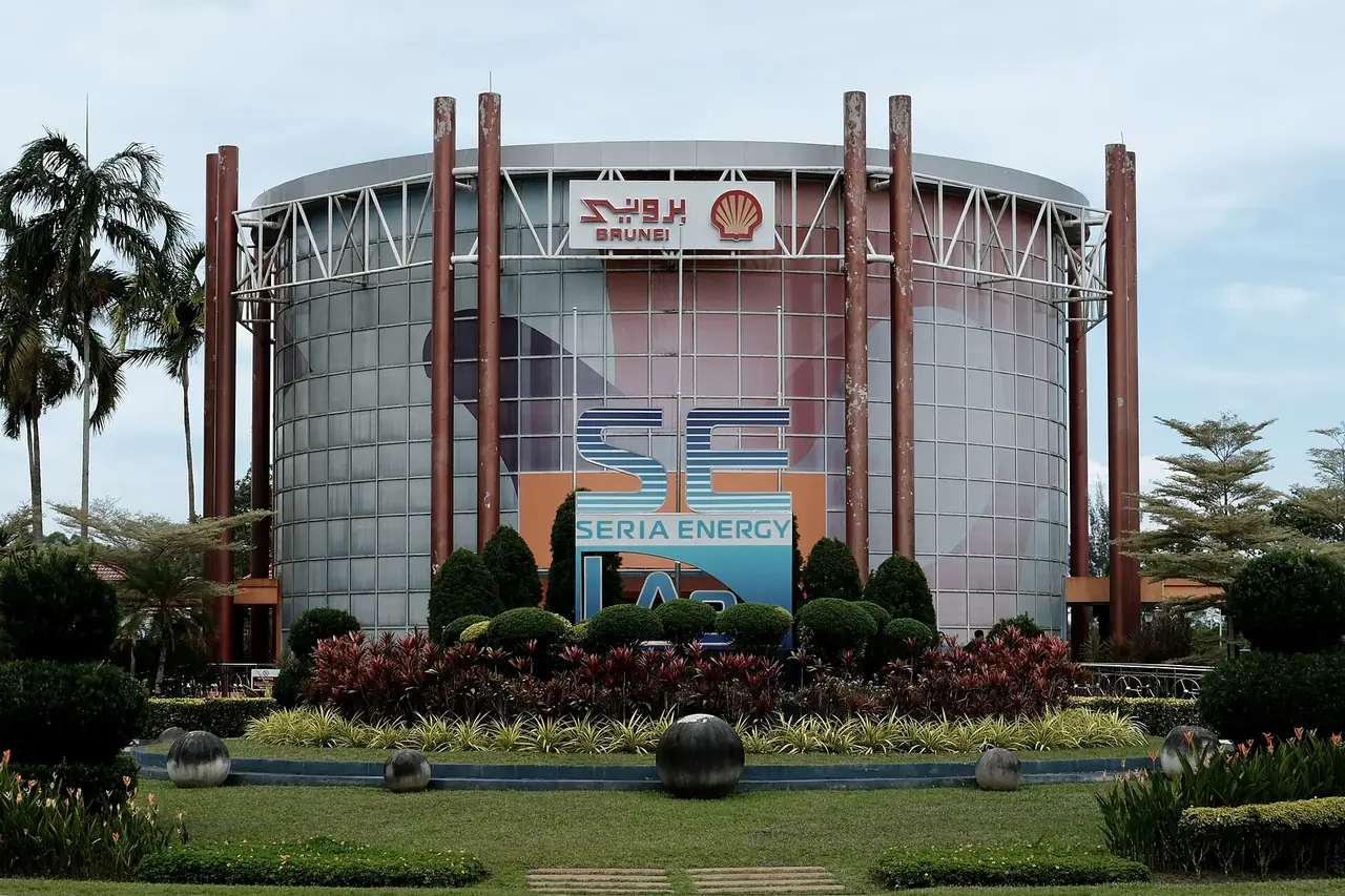 อาคารทรงกระบอกกระจกของ Seria Energy Lab ป้ายชื่อและสวนหน้าอาคาร ภาพจาก Wikimedia Commons ผู้ถ่าย Yu Chu Chin สัญญา CC BY-SA 4.0