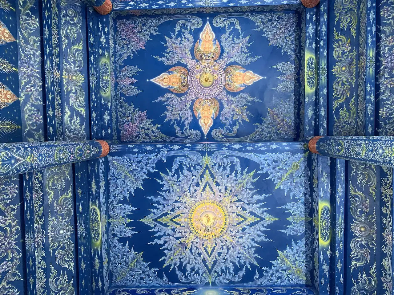 ลวดลายสีน้ำเงินและทองบนเพดานวัดร่องเสือเต้น