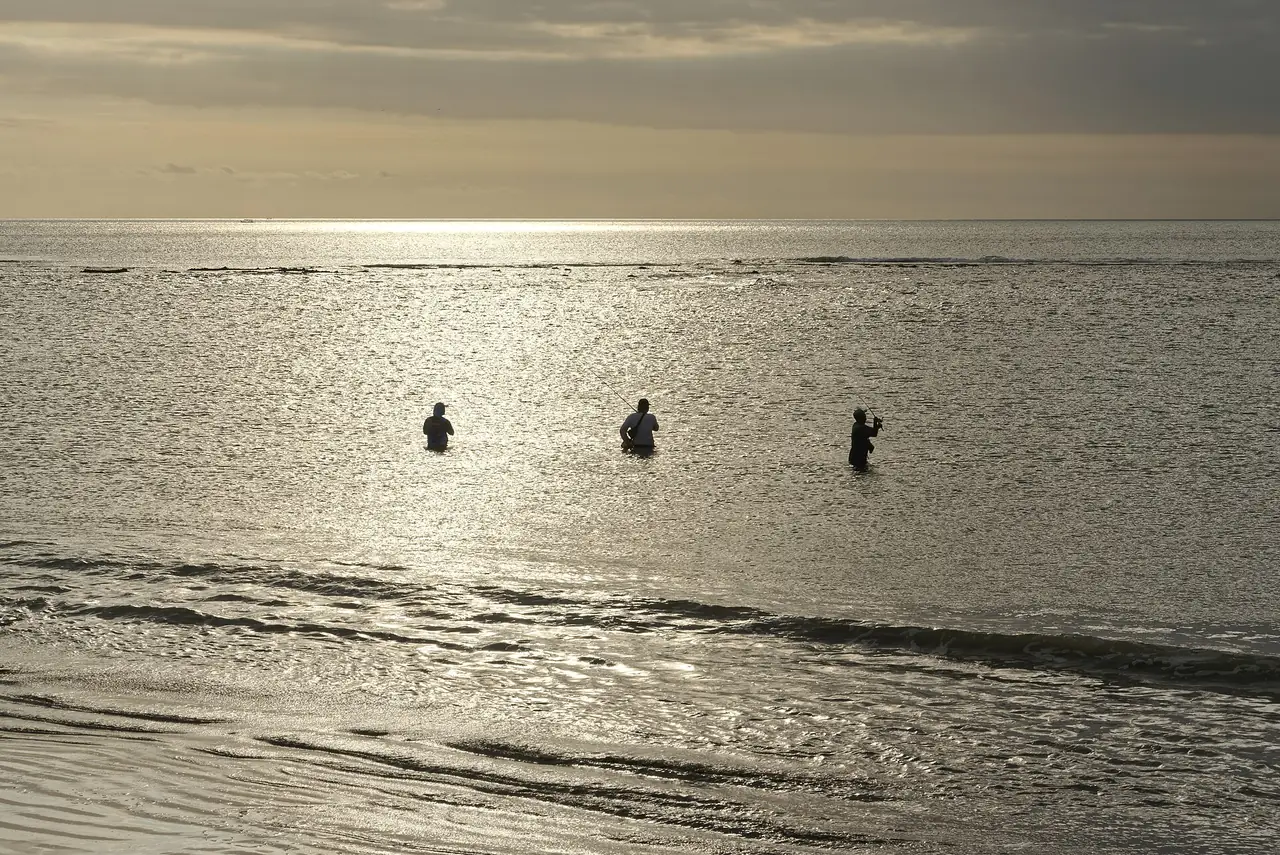 หาดกูตาตอนเย็น มีคนยืนในน้ำตื้น (ภาพบรรยากาศชายหาด)