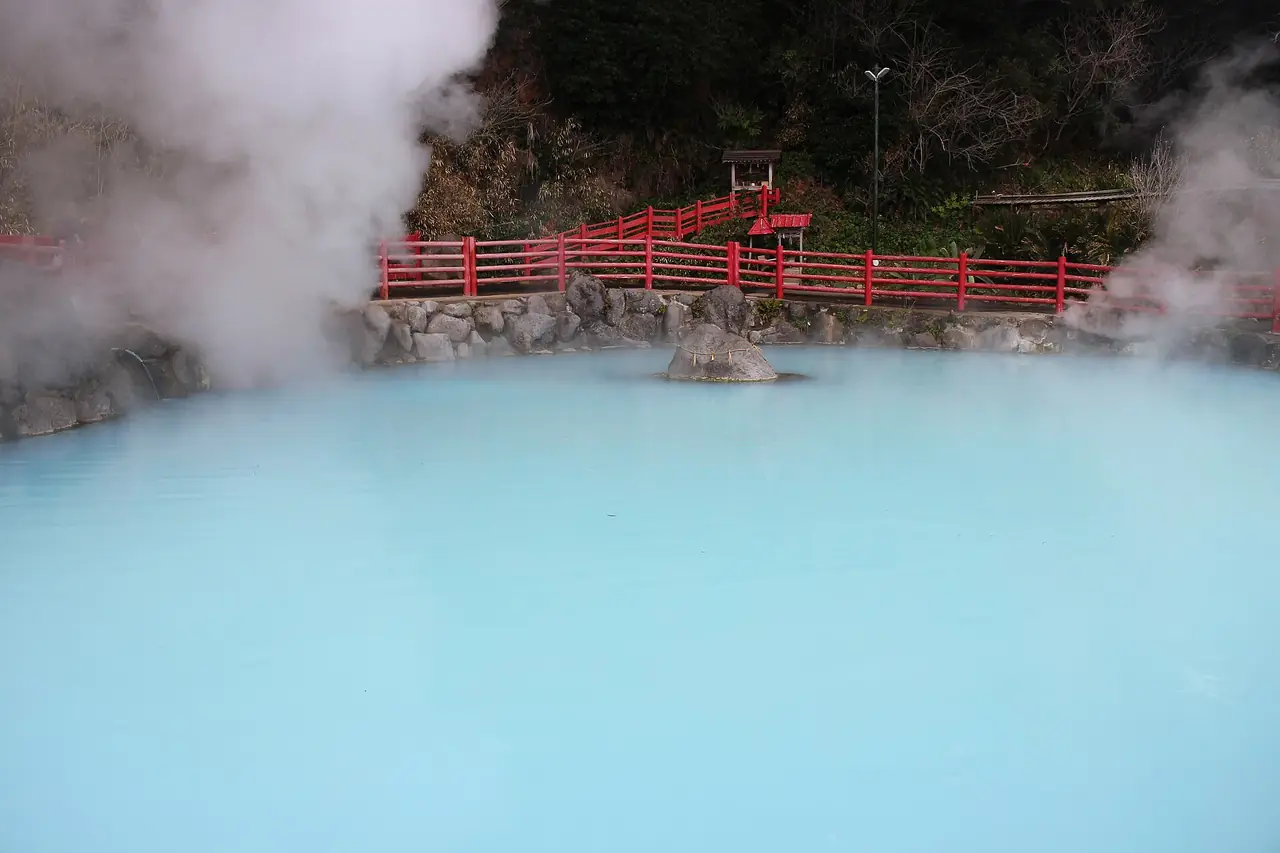 บ่อน้ำสีฟ้าและสะพานแดงท่ามกลางไอน้ำที่ Kamado Jigoku (ภาพสถานที่)