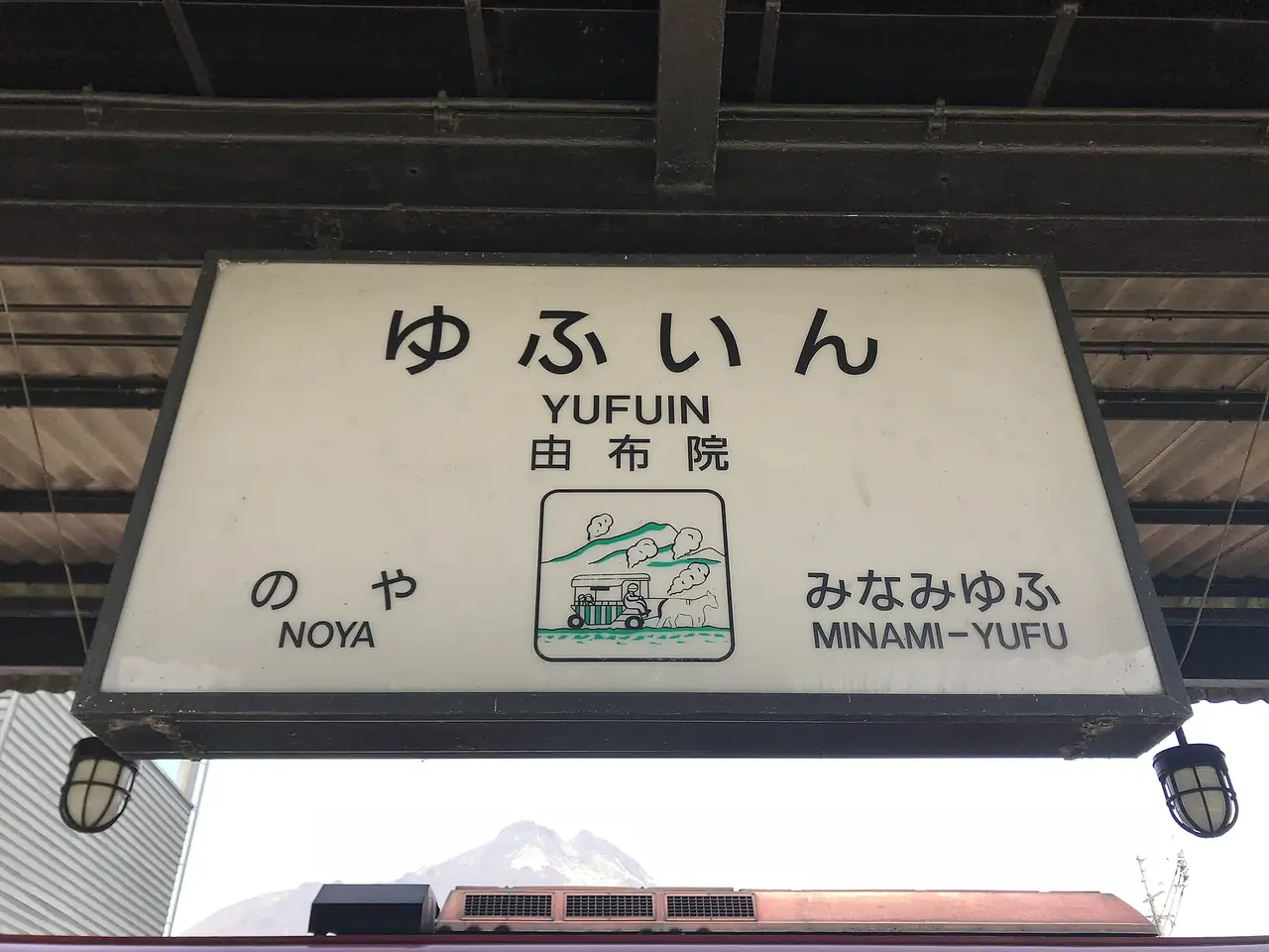ป้ายชื่อสถานียูฟุอิน มีภาพภูเขายูฟุและรถม้า (ภาพป้ายสถานี)