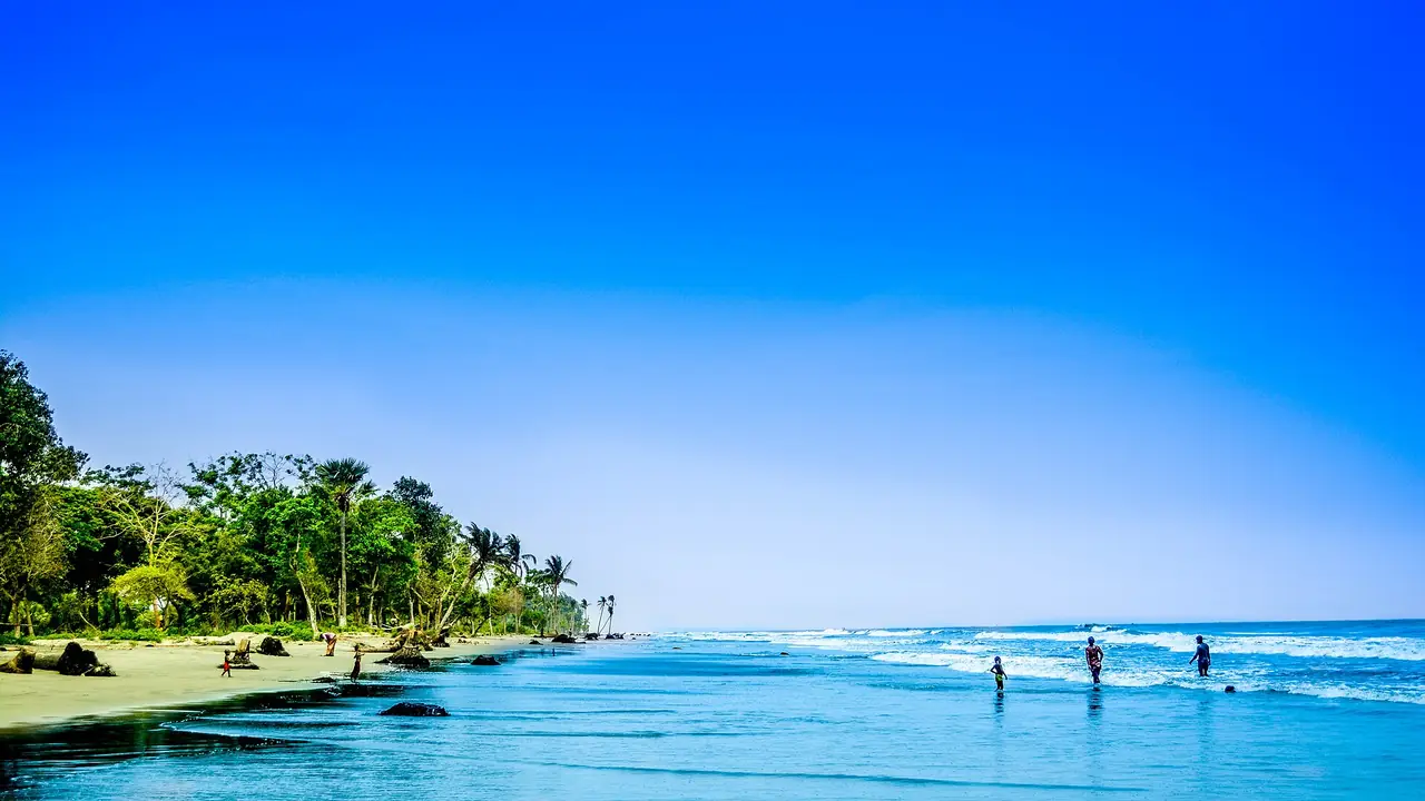 หาดกูอากาตาและคนเดินในน้ำตื้นใต้ท้องฟ้าสีฟ้า ภาพจาก Wikimedia Commons ผู้ถ่าย Fahimrb สัญญา CC BY-SA 4.0