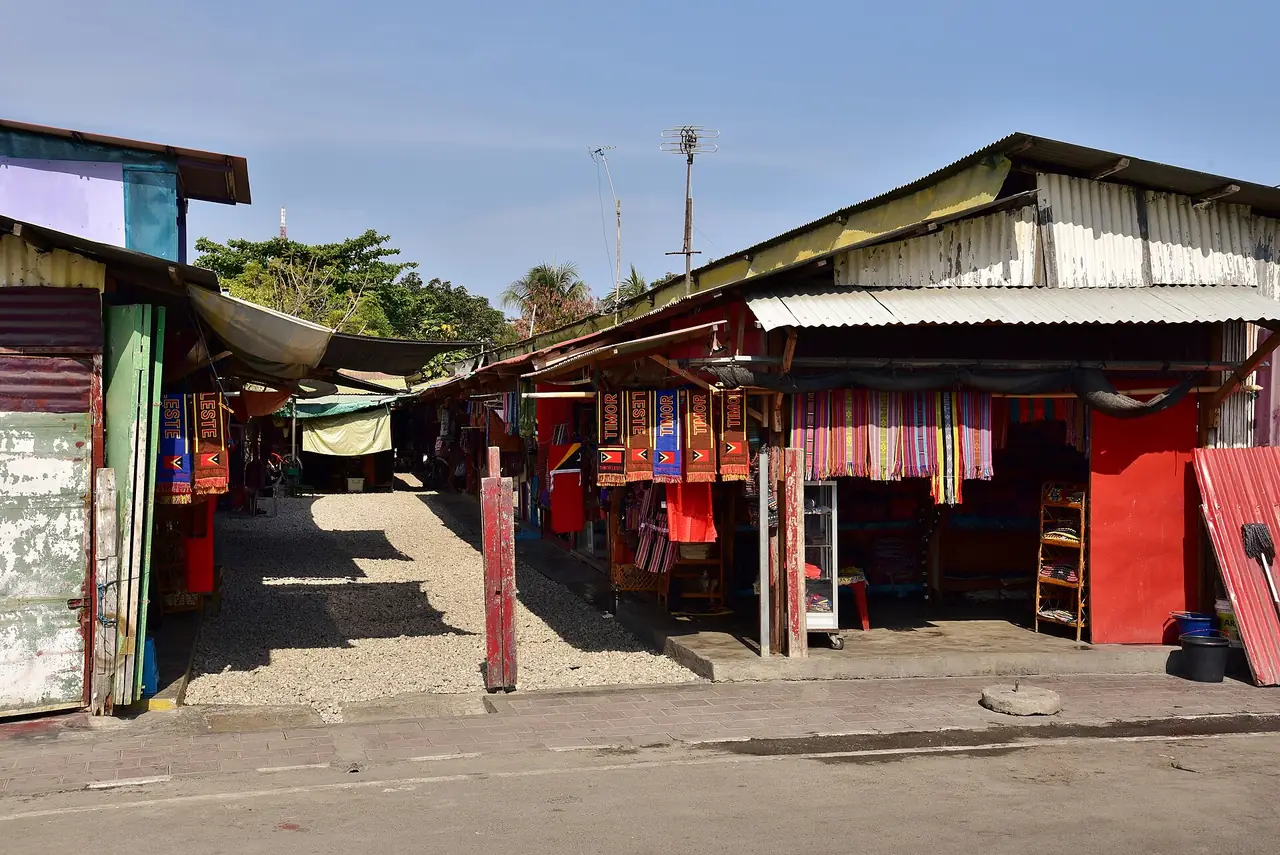 ร้านค้าหลังคาสังกะสีและแผงผ้าในตลาดทาอิสดิลี ภาพจาก Wikimedia Commons ผู้ถ่าย Bahnfrend สัญญา CC BY-SA 4.0 ถ่ายปี 2018 ตามชื่อไฟล์