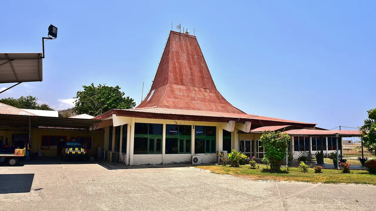 อาคารผู้โดยสารสนามบินดิลีมีหลังคาทรงบ้านพื้นเมืองสีแดง ภาพจาก Wikimedia Commons ผู้ถ่าย Bahnfrend สัญญา CC BY-SA 4.0 ถ่ายปี 2018 ตามชื่อไฟล์
