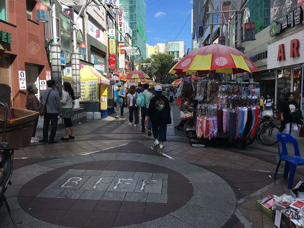 ลานวงกลม BIFF Square ที่ย่านนัมโพ มีแผงขายของและคนเดินบนถนน