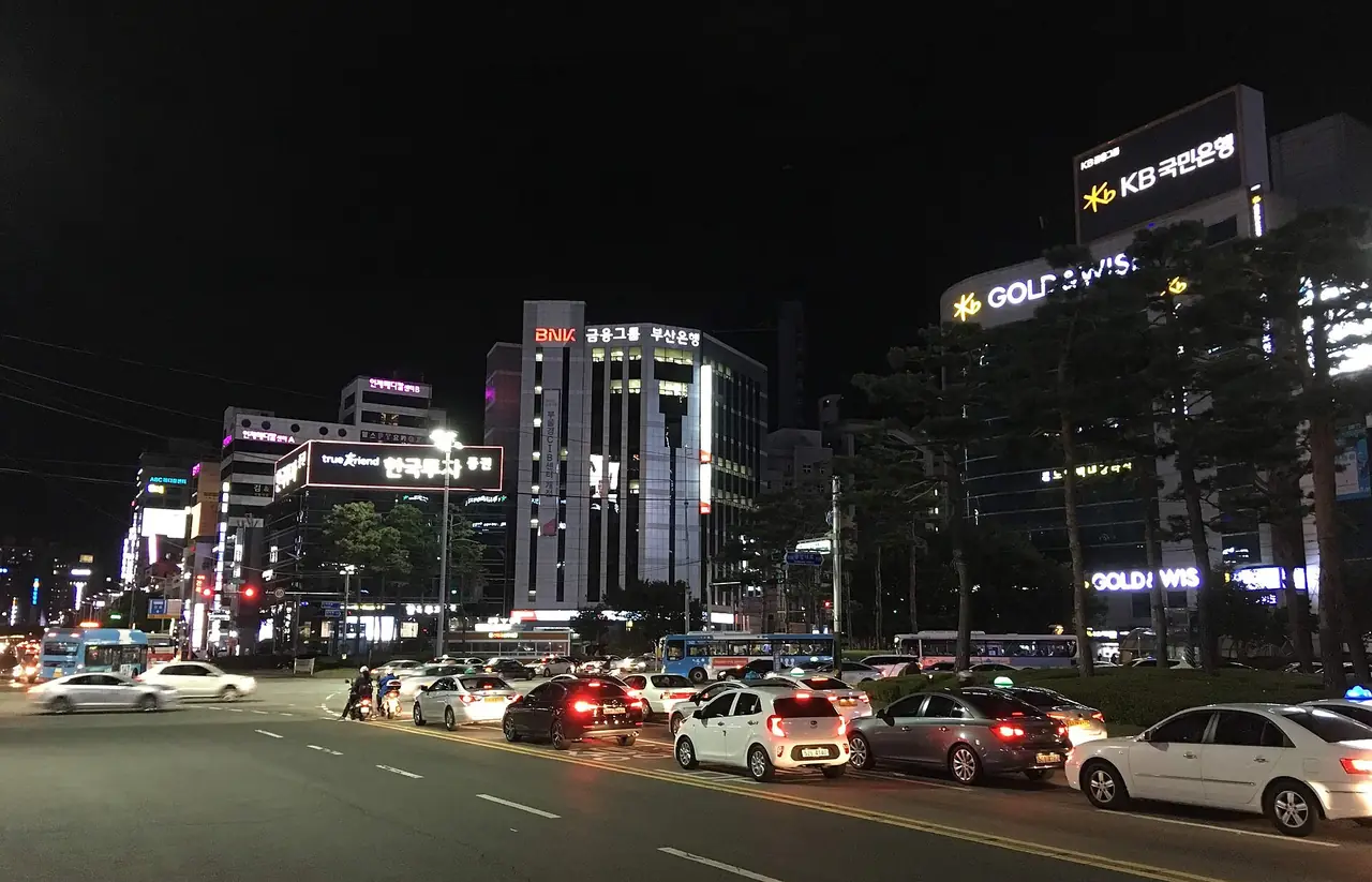 วงเวียนซอมยอนตอนกลางคืน มีรถและป้ายไฟของอาคารสำนักงานสองข้างถนน
