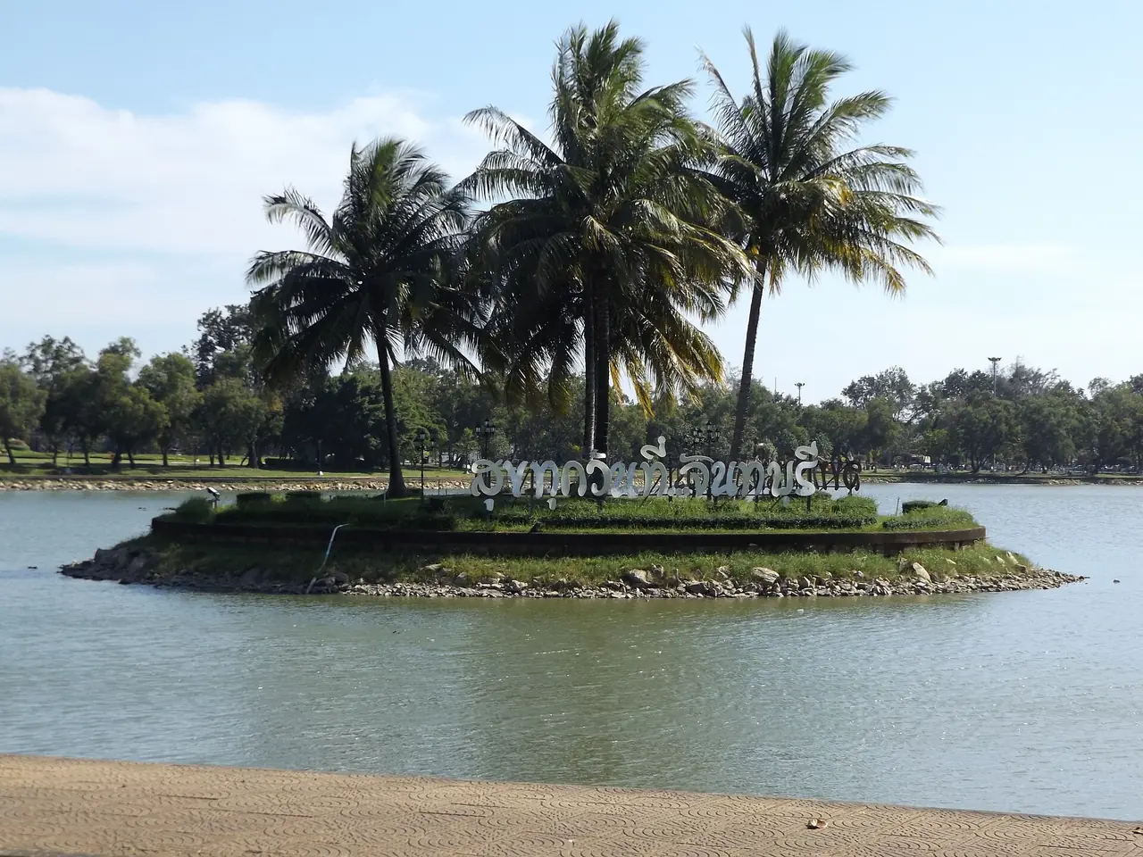 The pond and the Thai-language sign at Thung Na Choei Public Park in Chanthaburi