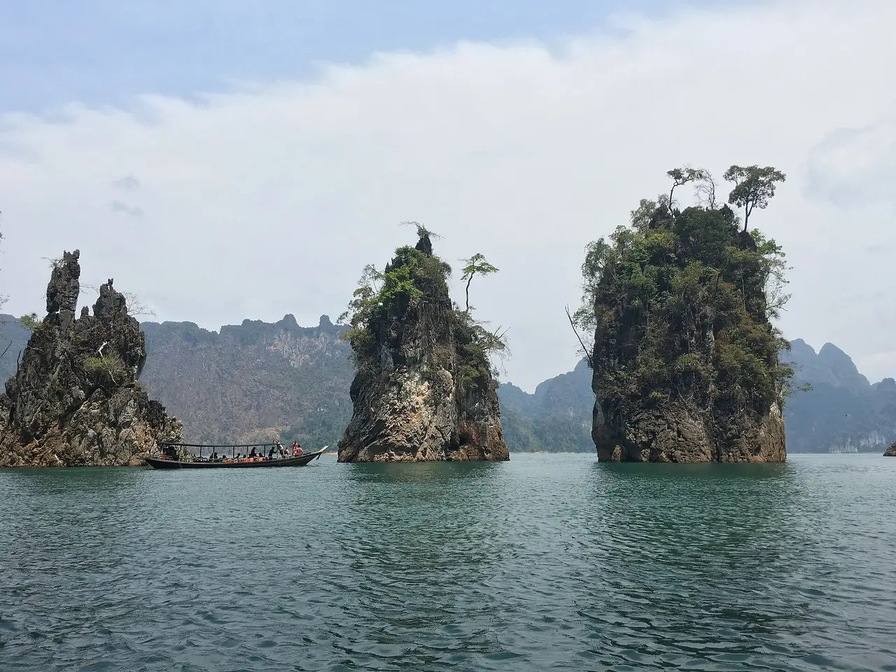 หินปูนสามก้อนกลางทะเลสาบ มีเรือหางยาวเล็ก ๆ ด้านหน้า ภาพของ Avenlarosa จาก Wikimedia Commons ผู้ถ่ายระบุว่าเป็นทริปเรือหางยาวส่วนตัว ไม่ได้ระบุชื่อโขดหิน