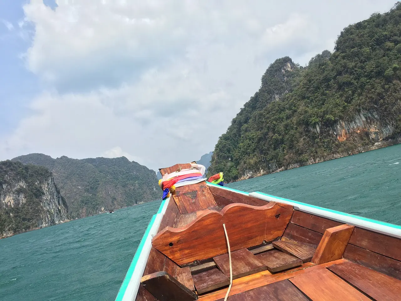 หัวเรือหางยาวและเขาหินปูนในทะเลสาบ ภาพของ Avenlarosa จาก Wikimedia Commons ผู้ถ่ายระบุว่าเป็นทริปเรือส่วนตัว