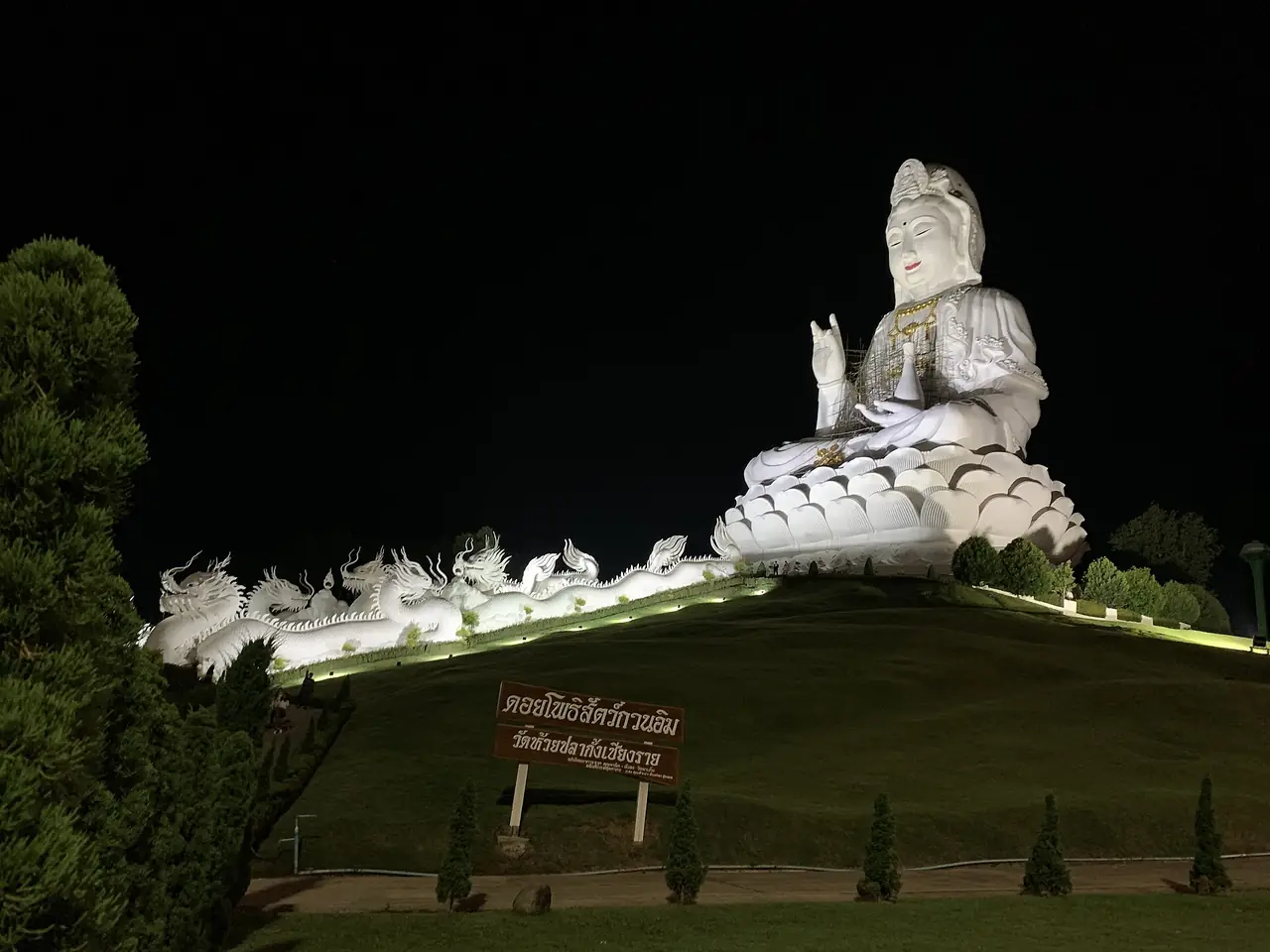 รูปปั้นองค์กวนอิมสีขาวขนาดใหญ่ที่วัดห้วยปลากั้งยามค่ำ ภาพถ่ายจาก Wikimedia Commons (Chainwit.)