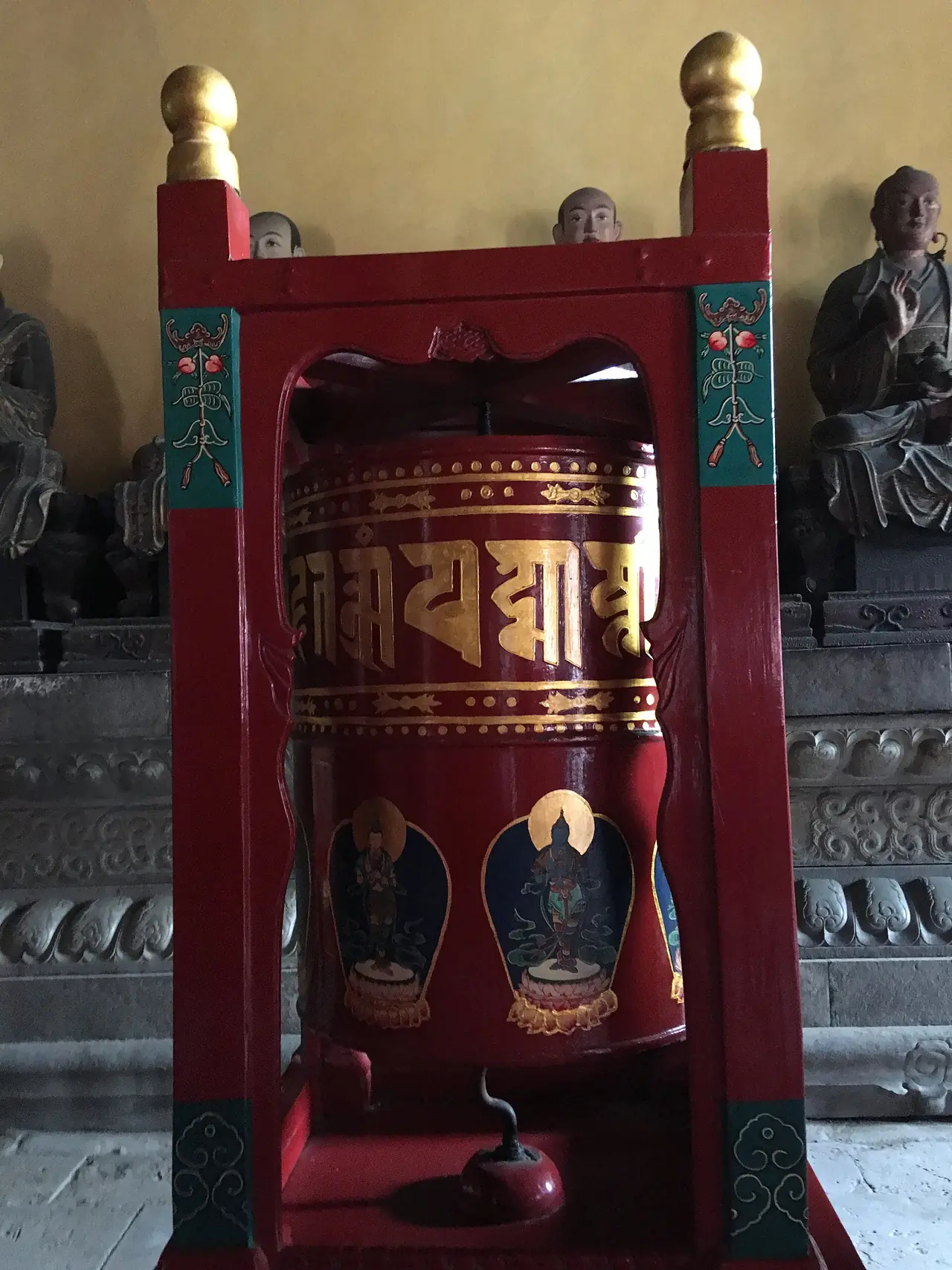 กงล้อมนตร์ทาสีแดงภายในวัดหย่งเหอ ด้านหลังเป็นรูปปั้น ภาพจาก Wikimedia Commons ผู้ถ่าย Bjoertvedt สัญญา CC BY-SA 4.0