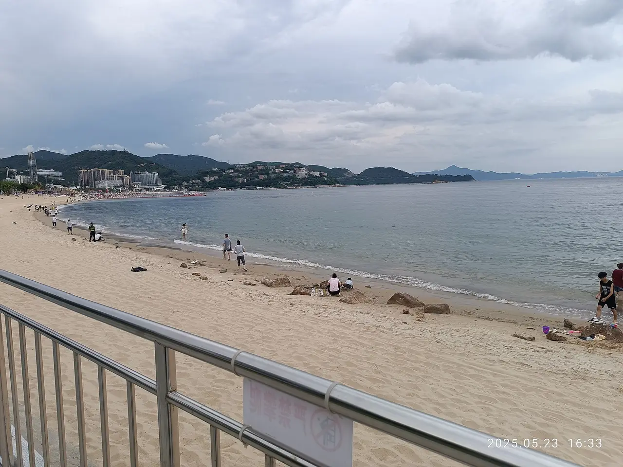 หาดทรายและอ่าวที่ต้าเหมยซา มีรั้วกั้นและป้ายคนเล่นน้ำ ภาพจาก Wikimedia Commons ผู้ถ่าย MACAHWM Bewizo Hom สัญญา CC0 ภาพถ่ายวันที่ 23 พ.ค. 2568 เวลา 16:33 ตามตราประทับ