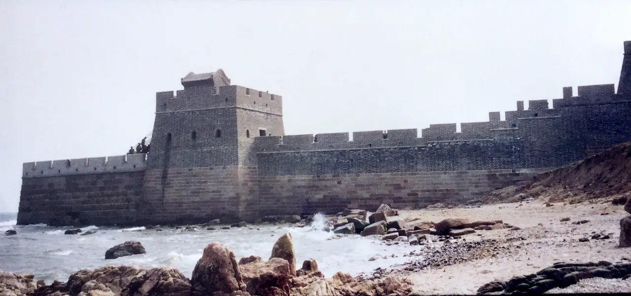 หัวมังกรเก่า จุดที่กำแพงเมืองจีนลงไปสบทะเลโป๋ไห่ ภาพถ่ายปี 1995 จาก Wikimedia Commons ผู้ถ่าย Prince Roy สัญญา CC BY 2.0 เป็นภาพเก่า สภาพปัจจุบันอาจไม่เหมือนเดิม