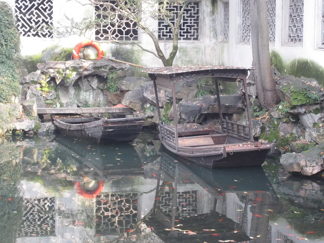 เรือไม้เล็กจอดริมสระน้ำใต้หินจัดสวนและหน้าต่างลายไม้ฉลุสีขาว ภาพจาก Wikimedia Commons ผู้ถ่าย Another Believer สัญญา CC BY-SA 4.0 ภาพปี 2558 ไม่แน่ชัดว่าเป็นมุมไหนของสวน