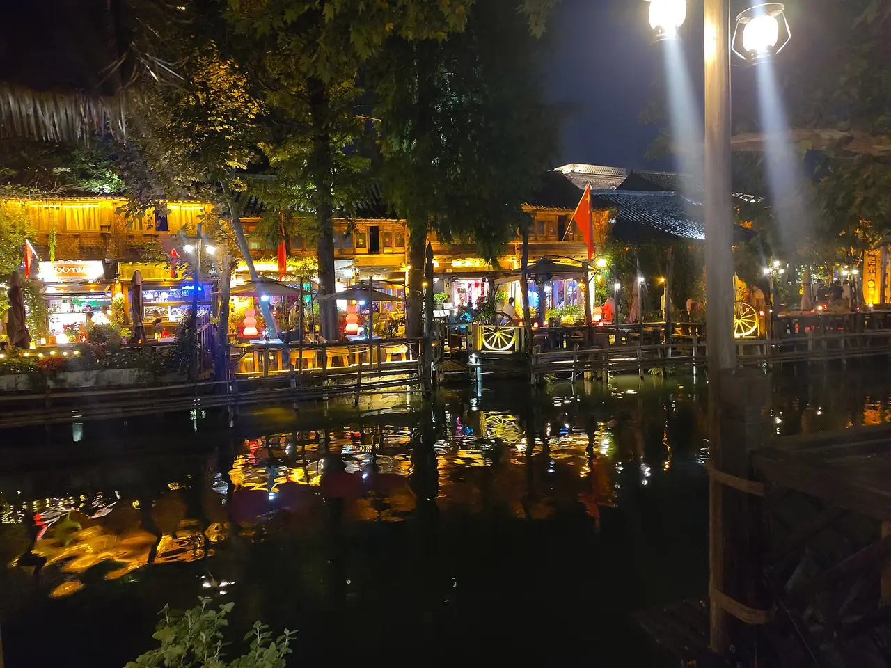 ร้านและศาลาริมน้ำในอูเจิ้นยามค่ำ แสงสีส้มและน้ำเงินสะท้อนบนผิวน้ำ ภาพจาก Wikimedia Commons ผู้ถ่าย Nico le terrible สัญญา CC0 ไม่ระบุปีที่ถ่ายและไม่ระบุโซน บรรยากาศปัจจุบันอาจต่างไป