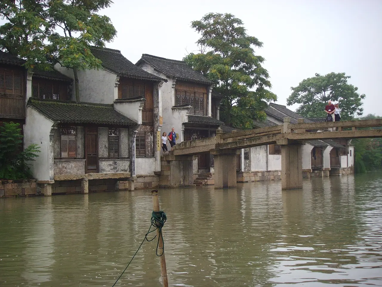 บ้านริมคลองและสะพานไม้ในโซนตะวันตกของอูเจิ้น ชื่อไฟล์ระบุปี 2552 ภาพจาก Wikimedia Commons ผู้ถ่าย Gerbil สัญญา CC BY-SA 3.0 เป็นภาพเก่า 17 ปีมาแล้ว