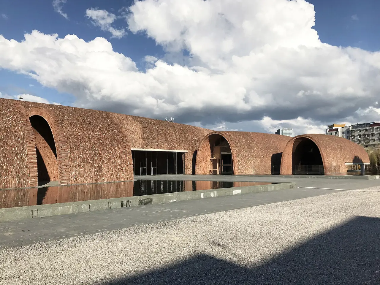 อาคารโค้งอิฐของพิพิธภัณฑ์เตาหลวงจิ่งเต๋อเจิ้น (Jingdezhen Imperial Kiln Museum) ออกแบบโดยจู่ เผย ภาพจาก Wikimedia Commons ผู้ถ่าย Zhu Pei สัญญา CC BY-SA 4.0 ไม่ระบุปีที่ถ่าย