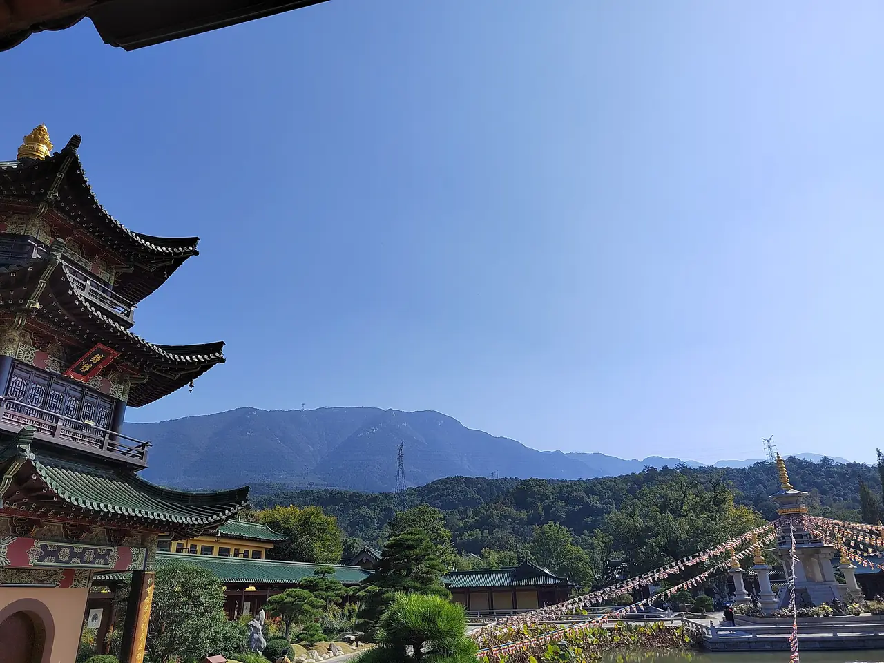 ศาลาหลายชั้นและเจดีย์ที่วัดตงหลิน (东林寺) เชิงเขาหลูซาน มีเทือกเขาเป็นฉากหลัง ถ่ายเมื่อ 21 ต.ค. 2566 ภาพจาก Wikimedia Commons ผู้ถ่าย 沈澄心 สัญญา CC0