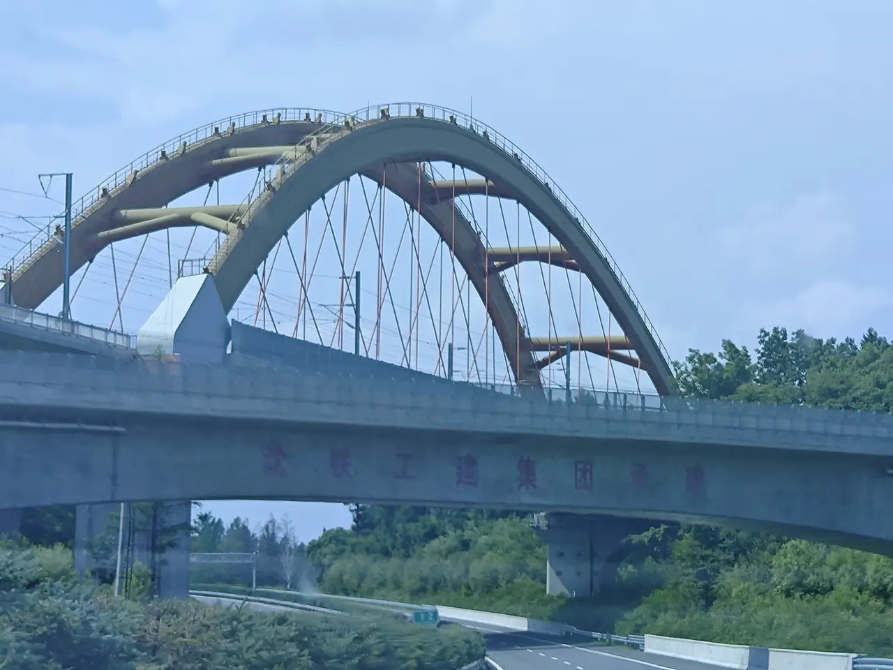 สะพานโค้งของสายรถไฟตุนฮว่า-ไป๋เหอ ข้ามทางด่วนใกล้ด่านเก็บเงินฉางไป๋ซานเหนือ ภาพจาก Wikimedia Commons ผู้ถ่าย Liuxingy สัญญา CC BY-SA 4.0 ไม่ระบุปีที่ถ่ายบนหน้า Commons