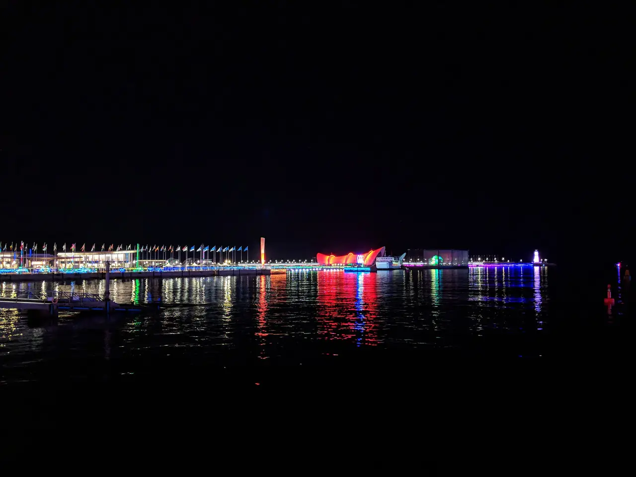 ไฟยามค่ำของศูนย์เรือใบนานาชาติเมื่อมองจากจัตุรัสอู่ซื่อ ภาพจาก Wikimedia Commons ผู้ถ่าย Gmbsfd สัญญา CC BY-SA 4.0 ไฟล์ตั้งชื่อวันที่ 8 พ.ค. 2561 เป็นภาพกลางคืน