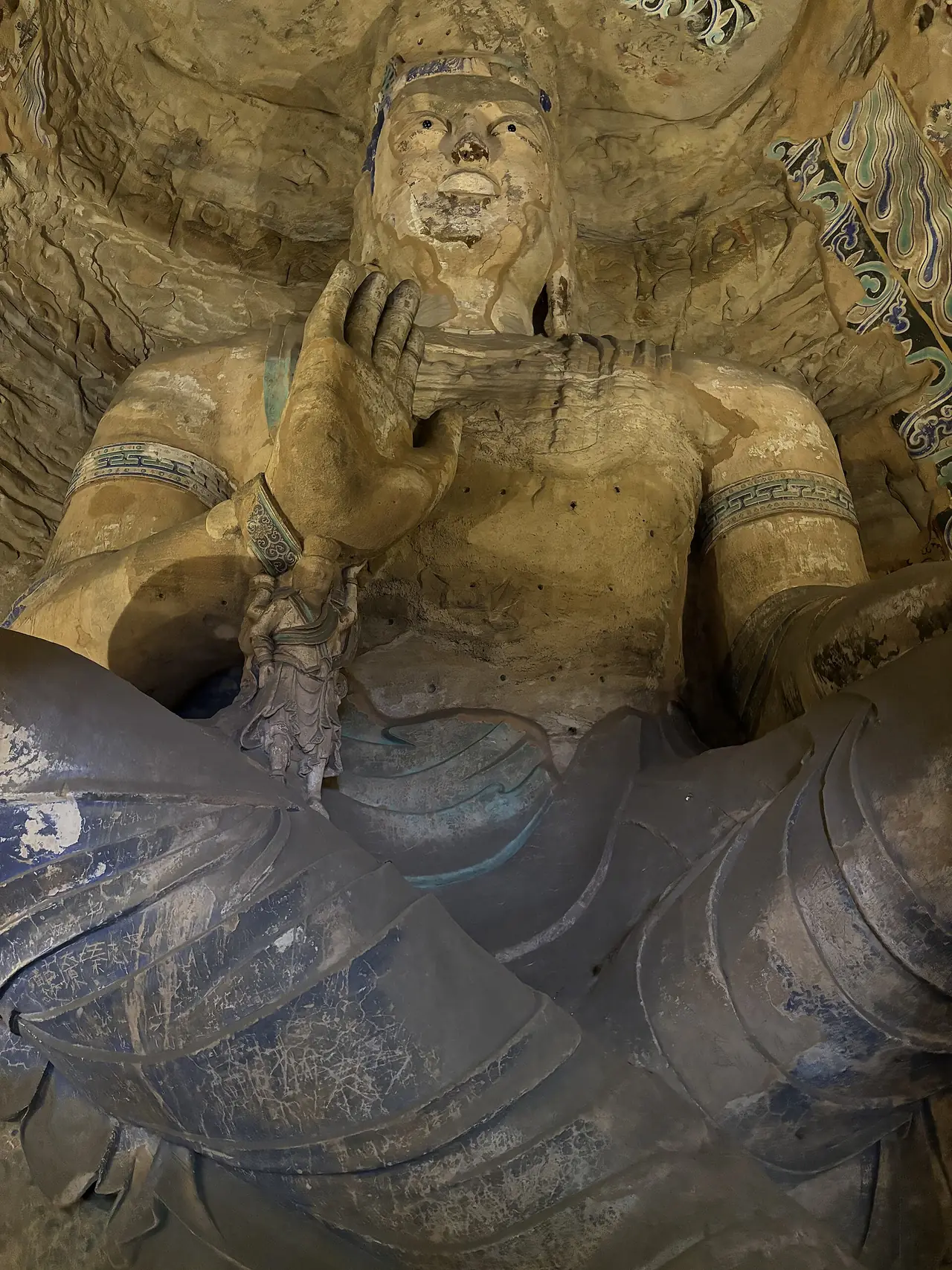 พระนั่งยกมือขึ้นในถ้ำที่ 13 ภาพจาก Wikimedia Commons ผู้ถ่าย Thebrainchamber1 สัญญา CC BY-SA 4.0 ไม่ระบุปีที่ถ่ายในหน้าไฟล์
