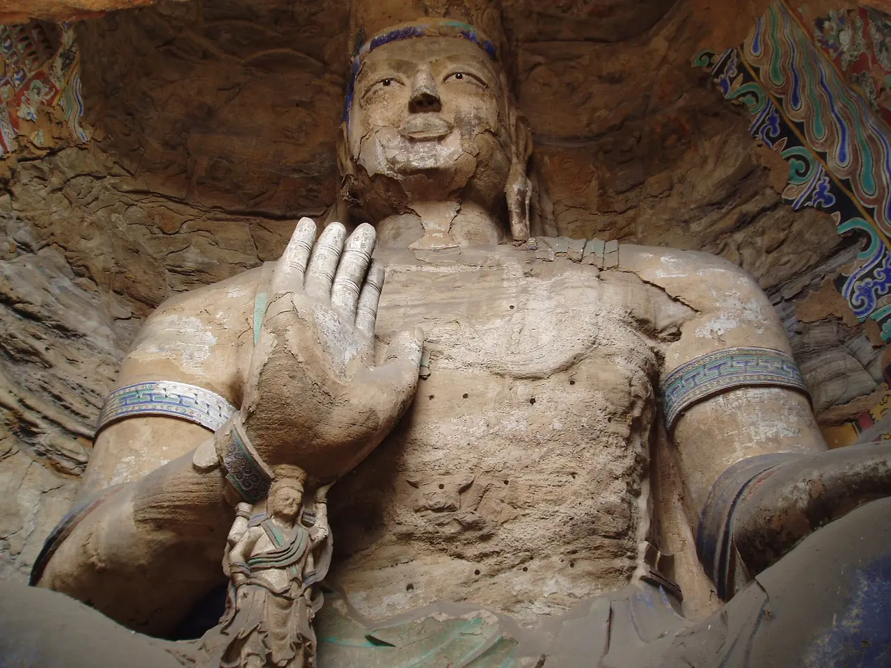 พระนั่งยกมือในถ้ำแห่งหนึ่งของหยุนกัง ภาพจาก Wikimedia Commons ผู้ถ่าย Steve Cadman สัญญา CC BY-SA 2.0 ไม่ระบุปีที่ถ่ายในหน้าไฟล์