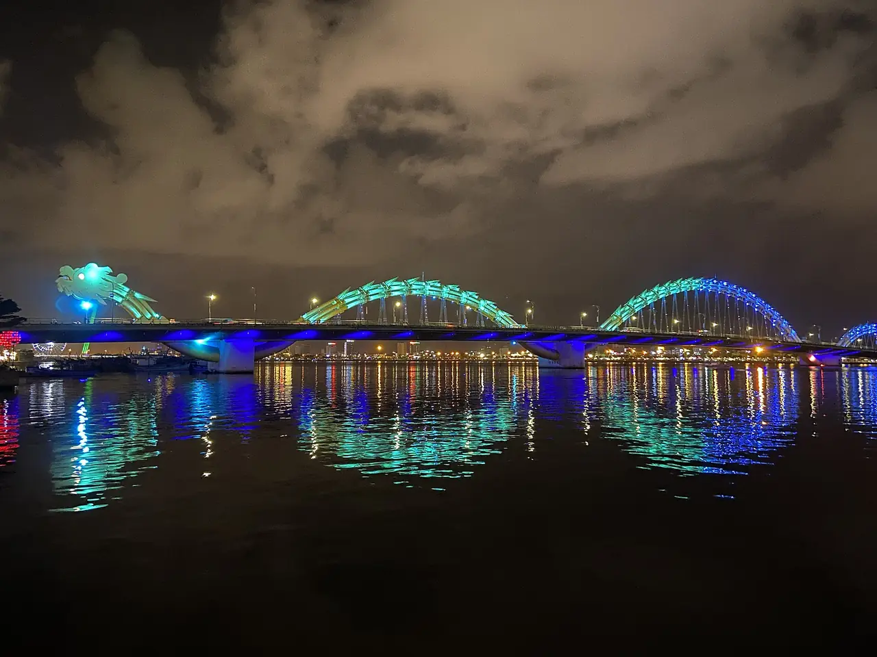 สะพานมังกรประดับไฟสีฟ้าเขียวยามค่ำ สะท้อนเงาลงแม่น้ำฮัน