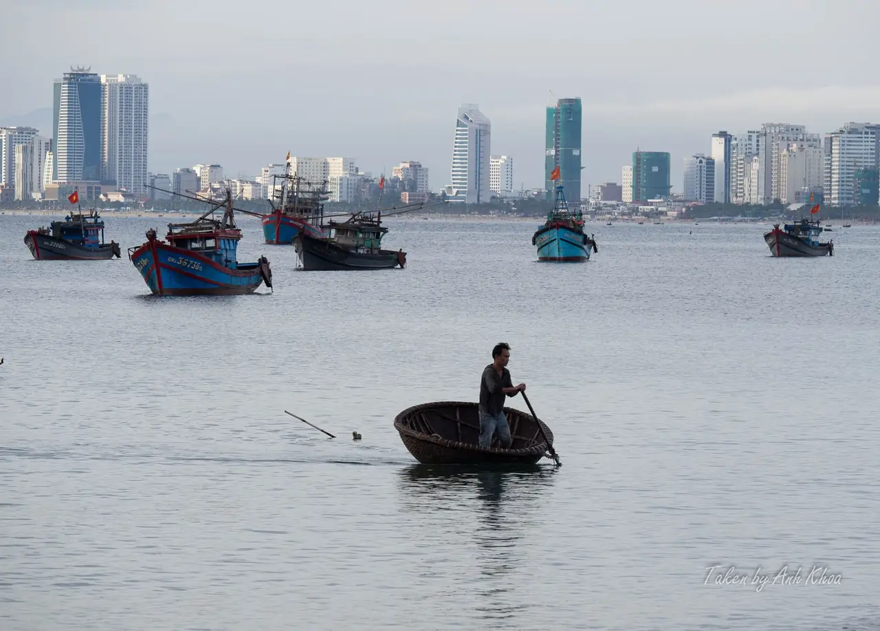 เรือประมงกลมในอ่าวและแนวตึกสูงของดานังเป็นฉากหลัง