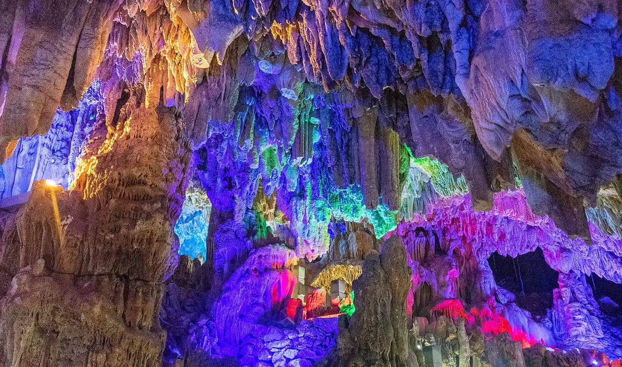 ภายในถ้ำขลุ่ยอ้อ ไฟสีส่องหินปูนเป็นลวดลาย ภาพจากคอมมอนส์