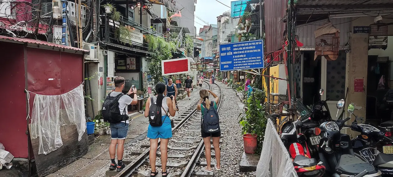 นักท่องเที่ยวบนรางถนนรถไฟ ฮานอย ข้างป้ายห้าม