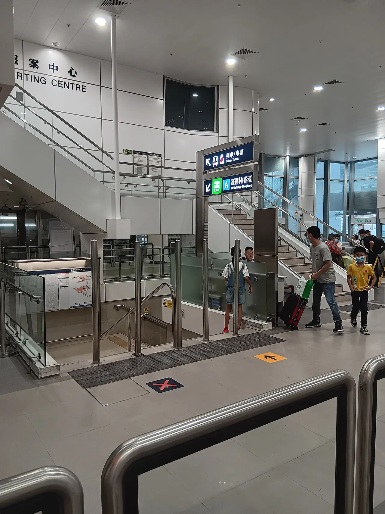 ทางออกของสถานี Lo Wu ฝั่งฮ่องกง ป้ายภาษาอังกฤษและจีนชี้ไปที่ขึ้นรถไฟและทางไปหมู่บ้าน Lo Wu ภาพจาก Wikimedia Commons ผู้ถ่าย Timothytyy สัญญา CC BY-SA 4.0 ไม่ระบุปีถ่ายในหน้าไฟล์