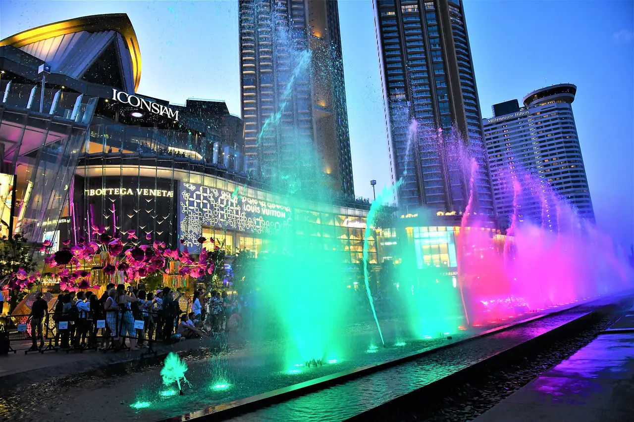Coloured fountain jets and the ICONSIAM facade at dusk