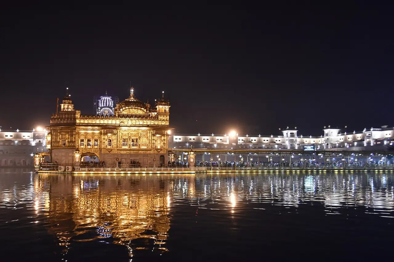 วิหารทองคำ (Harmandir Sahib) ยามค่ำคืนสะท้อนผิวสระ อมฤตสาร์ ภาพจาก Wikimedia Commons ผู้ถ่าย shankar s. จากดูไบ สัญญา CC BY 2.0 ถ่ายปี 2560 ตามชื่อไฟล์