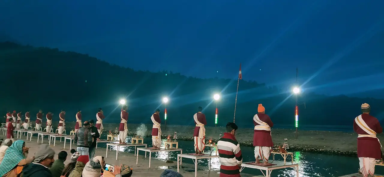 พิธีคงคาอารตีที่ท่าตรีเวณี (Triveni Ghat) ฤๅษีเกศ นักบวชเรียงแถวริมแม่น้ำตอนค่ำ ภาพจาก Wikimedia Commons ผู้ถ่าย Bhuvi Uniyal สัญญา CC BY-SA 4.0