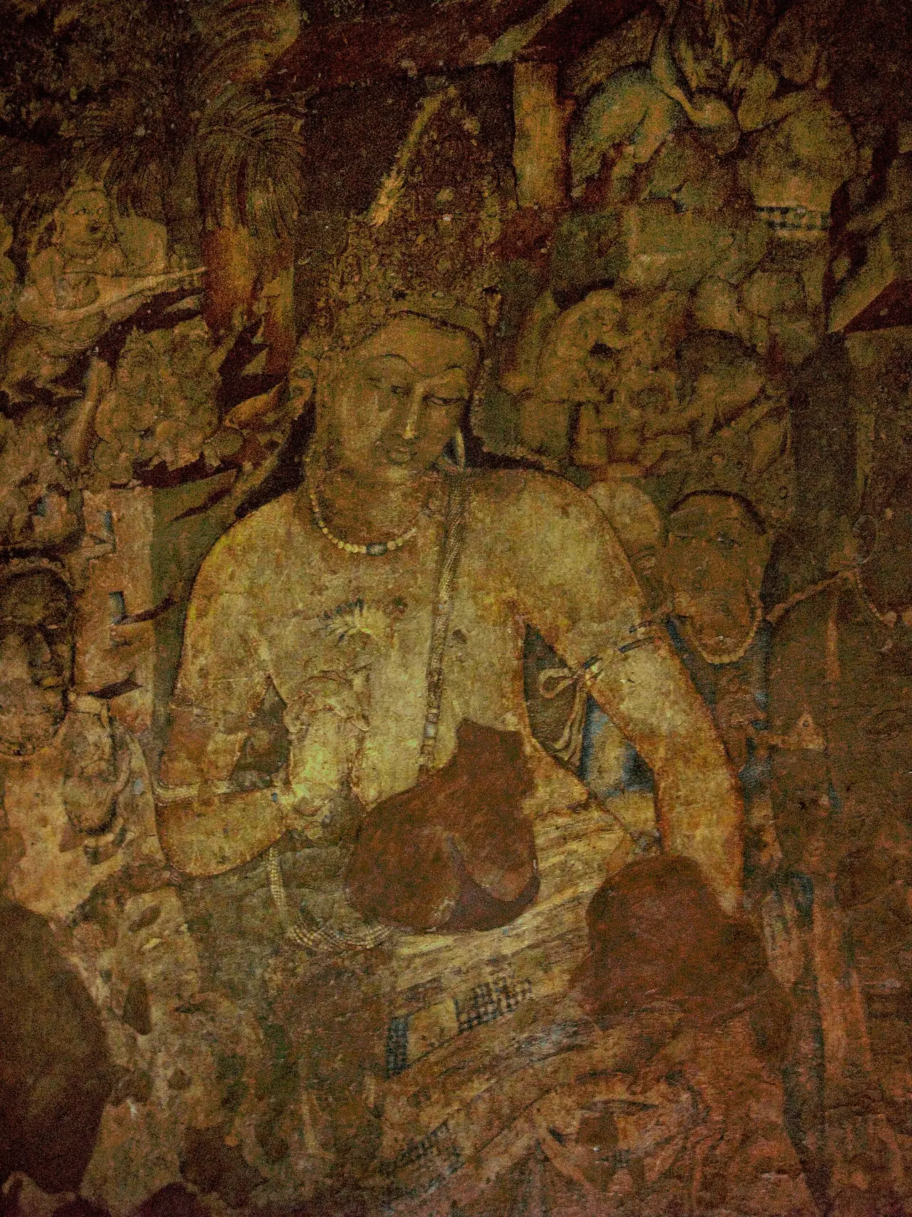 ภาพเขียนโพธิสัตว์ปัทมปาณีในถ้ำ 1 ที่อชันตา ภาพจาก Wikimedia Commons ผู้ถ่าย Abdulsayed สัญญา CC BY-SA 3.0 เป็นภาพถ่ายงานจิตรกรรมโบราณ แสงในถ้ำมืด สีจึงดูต่างจากของจริงได้