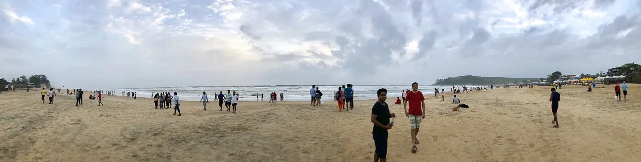 ทัศนียภาพหาดบาก้า (Baga Beach) ผู้คนเดินเล่นบนทรายกว้าง ภาพพาโนรามาจาก Wikimedia Commons ผู้ถ่าย Slyronit สัญญา CC BY-SA 4.0