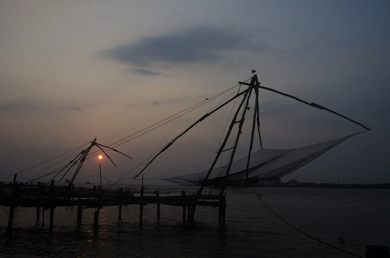 อวนจับปลาจีน (Chinese Fishing Nets) ที่ฟอร์ตโคชิ ยามเย็นเห็นเป็นเงาดำ ภาพจาก Wikimedia Commons ผู้ถ่าย Rangan Datta Wiki สัญญา CC BY-SA 4.0