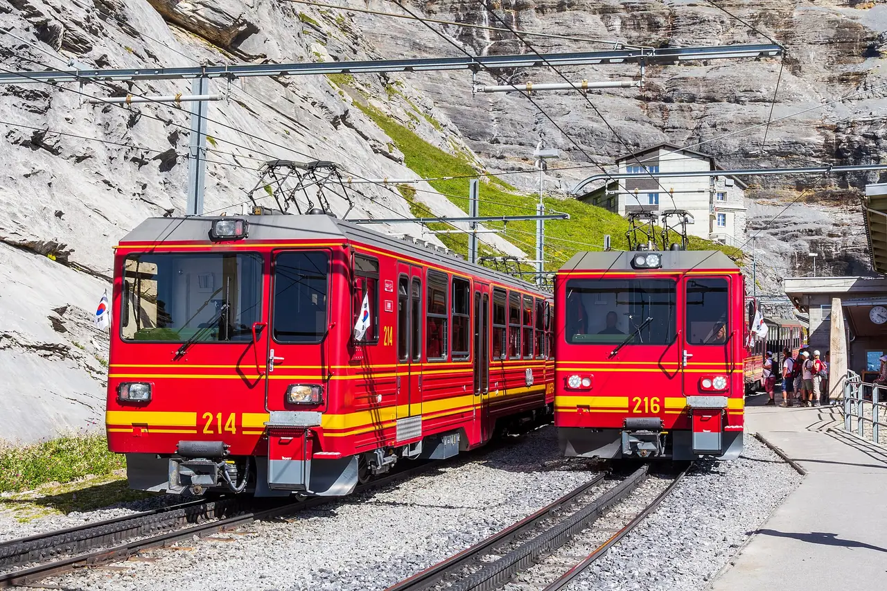 รถไฟยุงเฟราที่สถานี Eigergletscher รถไฟสีแดงและเหลือง ภาพถ่ายจาก Wikimedia Commons
