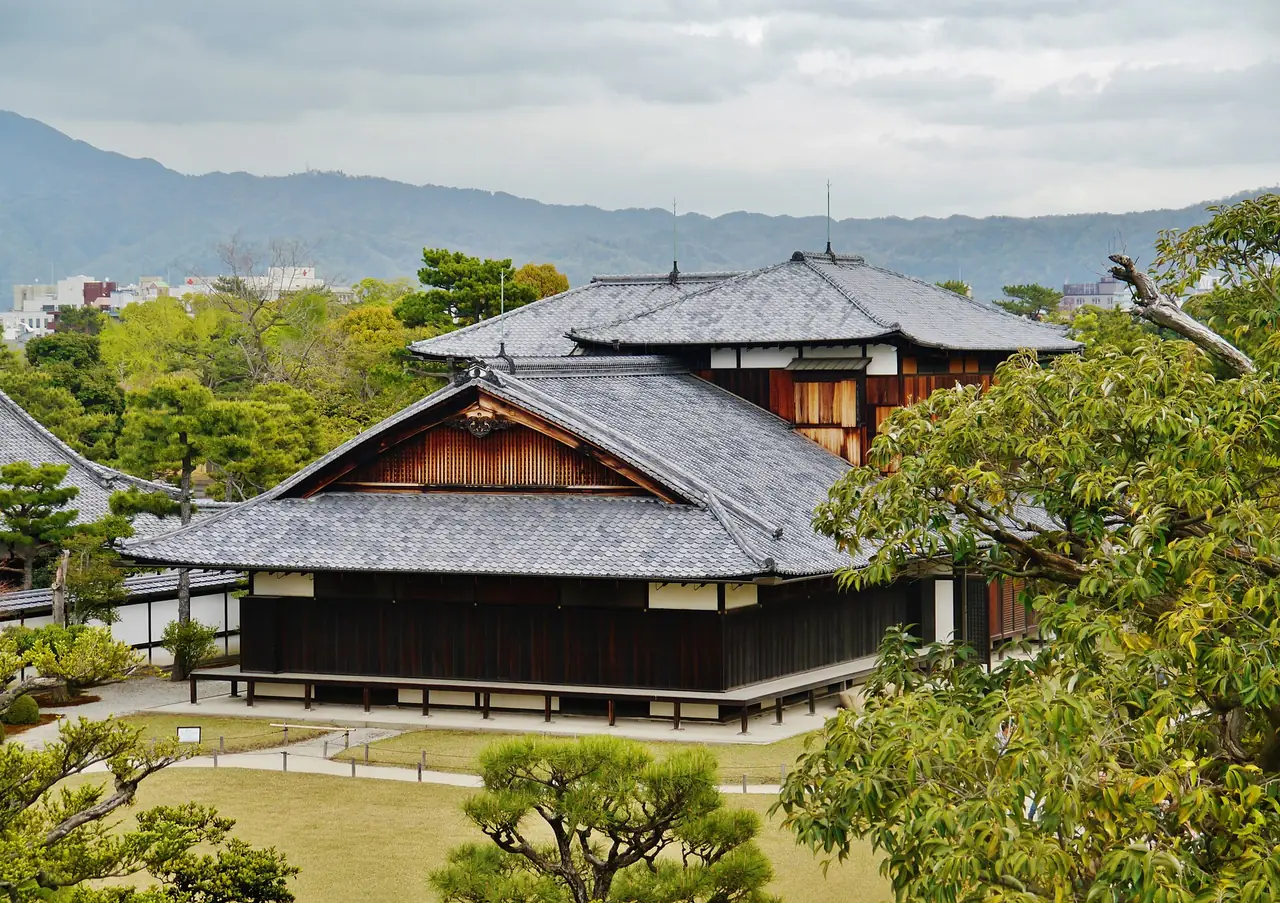 มองลงมาจากฐานหอคอยเก่าเห็นพระราชวังฮนมารุและภูเขารอบเกียวโต ภาพจาก Wikimedia Commons ผู้ถ่าย Zairon สัญญา CC BY-SA 4.0