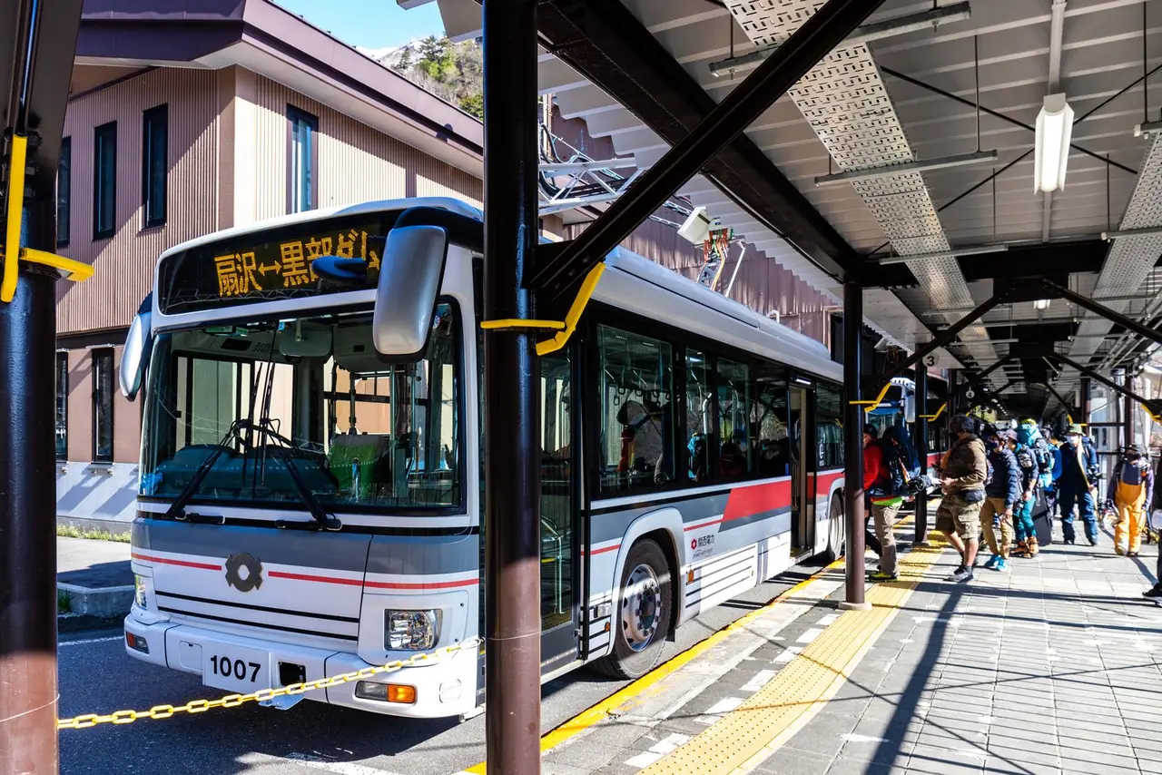 รถบัสไฟฟ้าอุโมงค์คันเดนที่ชานชาลาสถานีโอกิซาวะ ผู้โดยสารต่อแถวขึ้นรถ ภาพจาก Wikimedia Commons ผู้ถ่าย くろふね สัญญา CC BY 4.0 ภาพวันที่ 7 พ.ค. 2565