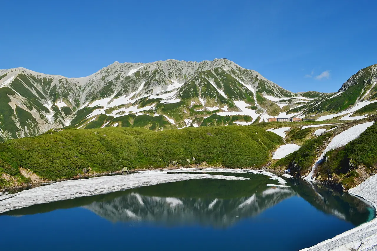 บ่อมิคุริงะอิเคะกับภูเขาทาเตยามะ มีหิมะเหลือรอบบ่อ ภาพจาก Wikimedia Commons ผู้ถ่าย Saigen Jiro สัญญา CC0 ไม่ระบุปีที่ถ่ายในคำอธิบาย