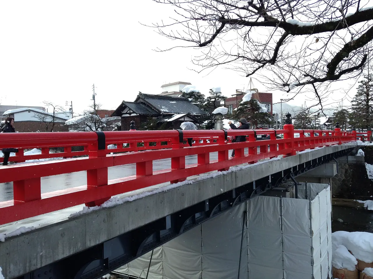 สะพานนากาบาชิสีแดงข้ามแม่น้ำมิยางาวะในวันหิมะตก ภาพจาก Wikimedia Commons ผู้ถ่าย そらみみ สัญญา CC BY-SA 4.0 ภาพวันที่ 23 ม.ค. 2558 ใต้สะพานมีผ้าคลุมงานก่อสร้างในวันนั้น