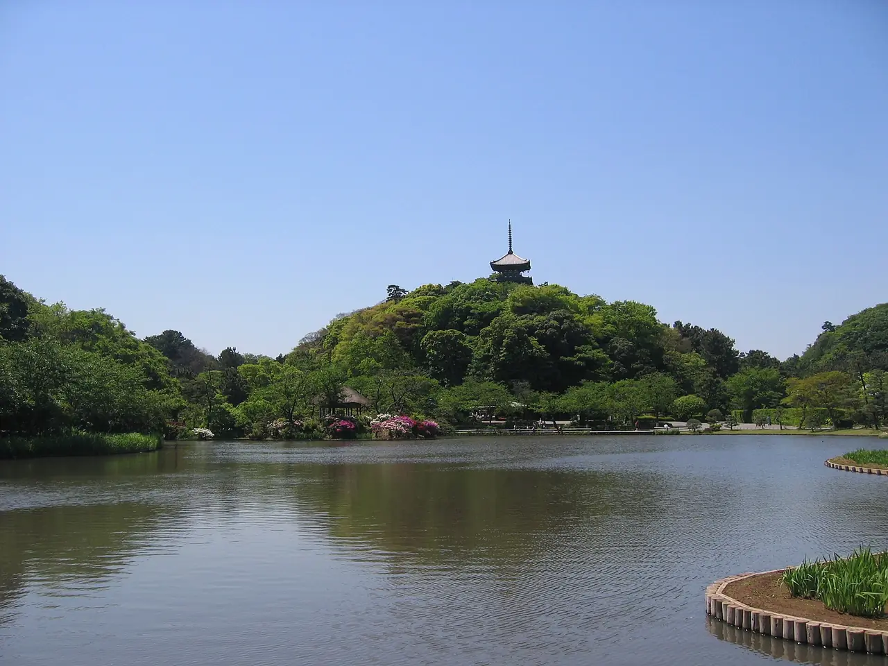 สระน้ำใหญ่ของสวนซังเคเอ็นกับเจดีย์สามชั้นบนเนินเขา ภาพจาก Wikimedia Commons ผู้ถ่าย Σ64 สัญญา CC BY-SA 3.0 ภาพเก่า